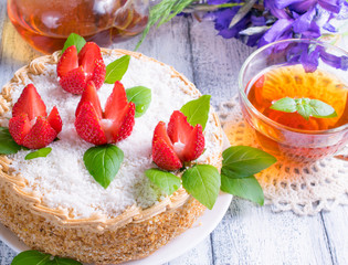 Celebratory cake with strawberries flowers, tea and irises