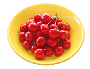 Ripe juicy cherries in a yellow plate on a white background