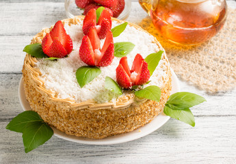 Celebratory cake with strawberry flowers and tea