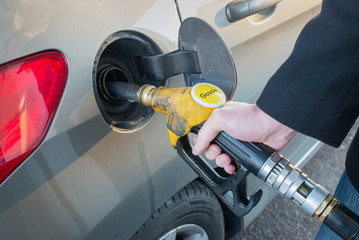 Pumping gas. Close up of man pumping gazole fuel in car at gas station.