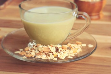 Oat flakes and milk on wooden background.