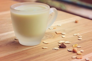 Oat flakes and milk on wooden background.