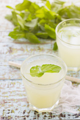 Obraz na płótnie Canvas Two glass of fresh lemonade decorated with mint leaves