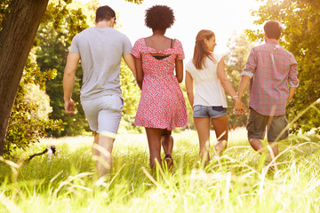 Fototapeta premium Two couples walking together in the countryside, back view
