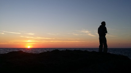 Fototapeta na wymiar Fishing at sunset