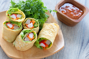 Vegetarian food,Homemade egg rolls and Sweet chili sauce on wood table