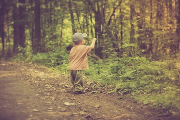 Vintage photo of boy playing in forest