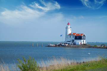lonely lighthouse stands on the spit in the sea near the village
