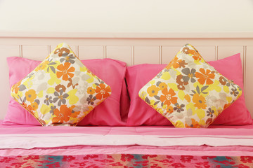 Colorful polka pillow on pink bed