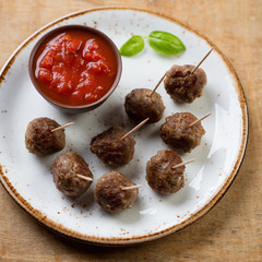 Close-up of skewers with meatballs and a dipping sauce