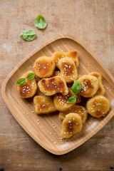 Bamboo tray with sesame chicken nuggets, above view, studio shot