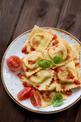 Above view of ravioli with tomato sauce on a dark wooden surface