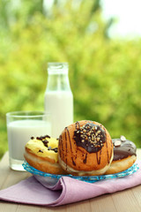 Donuts and glass of milk on a background of nature
