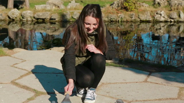Teenage Girl Feeding Pigeons Near Lake