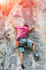 Rock climber climbing up a cliff