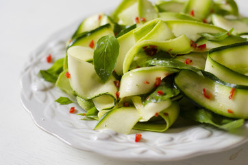 Salad from zucchini, lemon, chilli and basil 