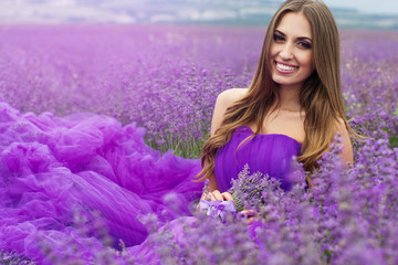 Beautiful smiling girl is wearing fashion dress at lavender