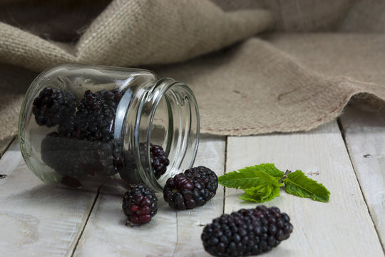 Blackberries in a jar and spilt on table