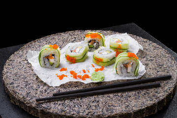 Traditional Japanese cuisine, sushi roll on a dark background.