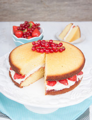 Victoria sponge cake with buttercream frosting, jam and strawberries
