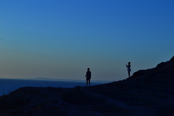 Couple taking photos each other at sunset
