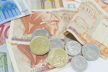 Greek drachma and euro banknotes on white