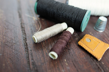 Thimble and needles for sewing close-up on a wood background. ma