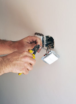 An electrician installing electrical switches during the reform of a house