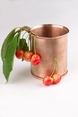 COPPER MUG with white cherries on a white background