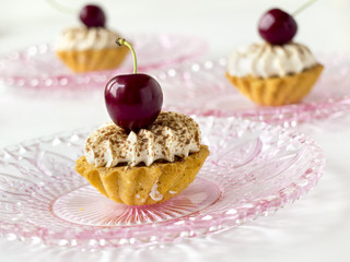 Cupcakes (three cakes) with cherries and whipped cream