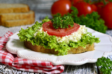 Sandwich from whole grain bread with cheese and vegetable.