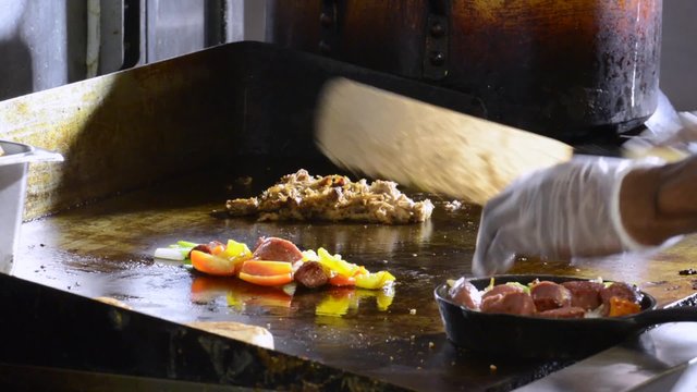 A chef plating food in a commercial restaurant kitchen
