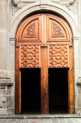 Giant wooden gate with smaller doors integrated on massive concrete style building