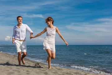 Fototapeta na wymiar happy couple in love walking on the beach