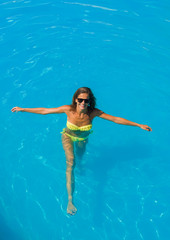 A girl is relaxing in a swimming pool