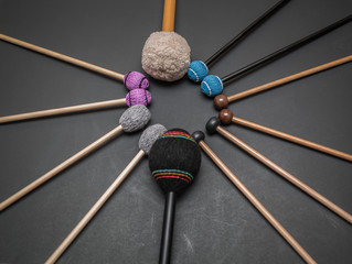 closeup view of drum and percussion orchestra natural hickory wood sticks on dark grey background