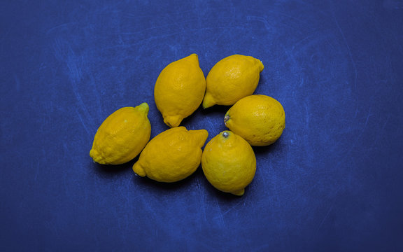 amazing closeup view of yellow organic fresh appetizing lemons on dark blue background