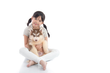 Beautiful asian girl hugging siberian husky puppy on white backg