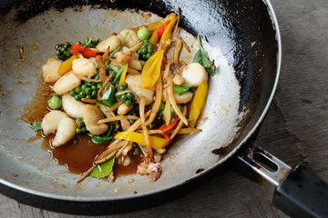 Shell fried clams in pan on wood  background