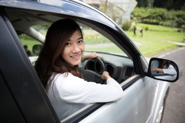 Fototapeta na wymiar Happy young asian woman riding a car