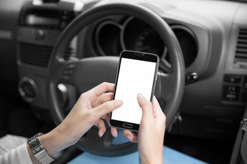 Woman's hands using cellphone inside a car, close up