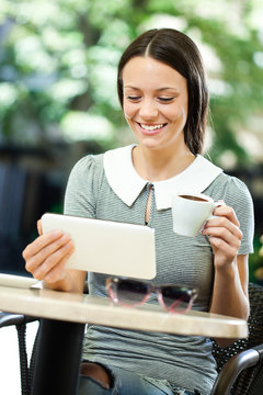 Young woman using digital tablet in a cafe