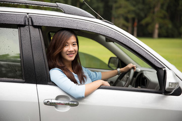 Fototapeta na wymiar Happy young asian woman riding a car