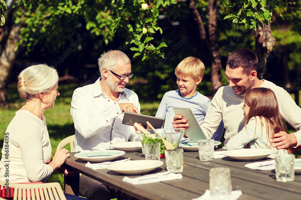 Wall mural happy family with tablet pc at table in garden