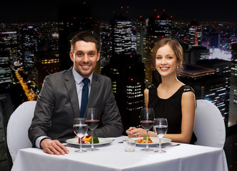 smiling couple eating main course at restaurant