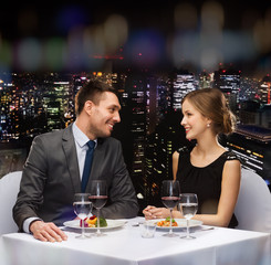 smiling couple eating main course at restaurant