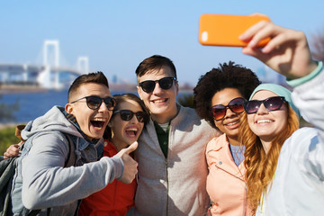 happy friends taking selfie with smartphone