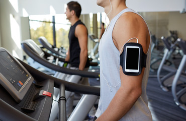 close up of man with smartphone in gym