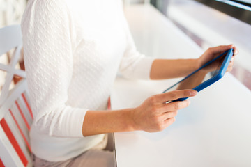 close up of woman with tablet pc at cafe