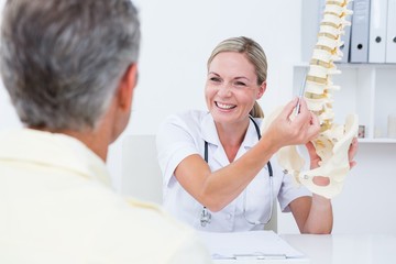 Doctor showing her patient a spine model